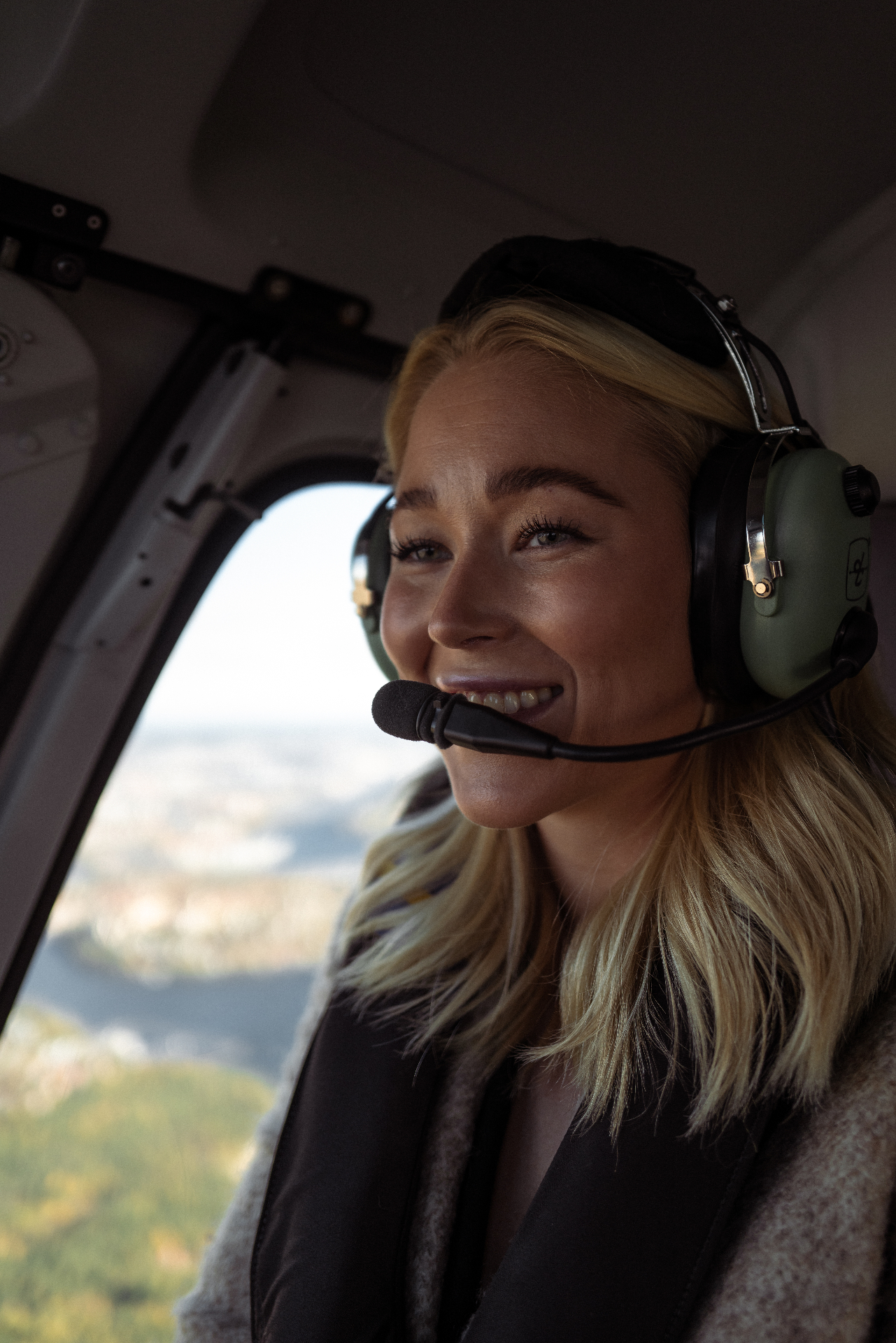 Leende kvinna med headset njuter av helikopterturen över Stockholm
