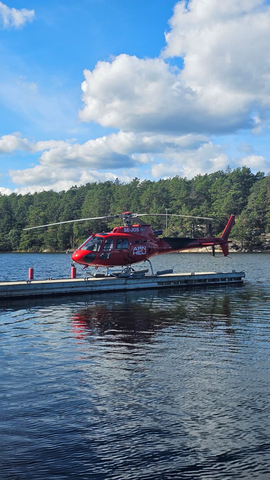 Arlanda Helicopter's red helicopter by a jetty in the archipelago