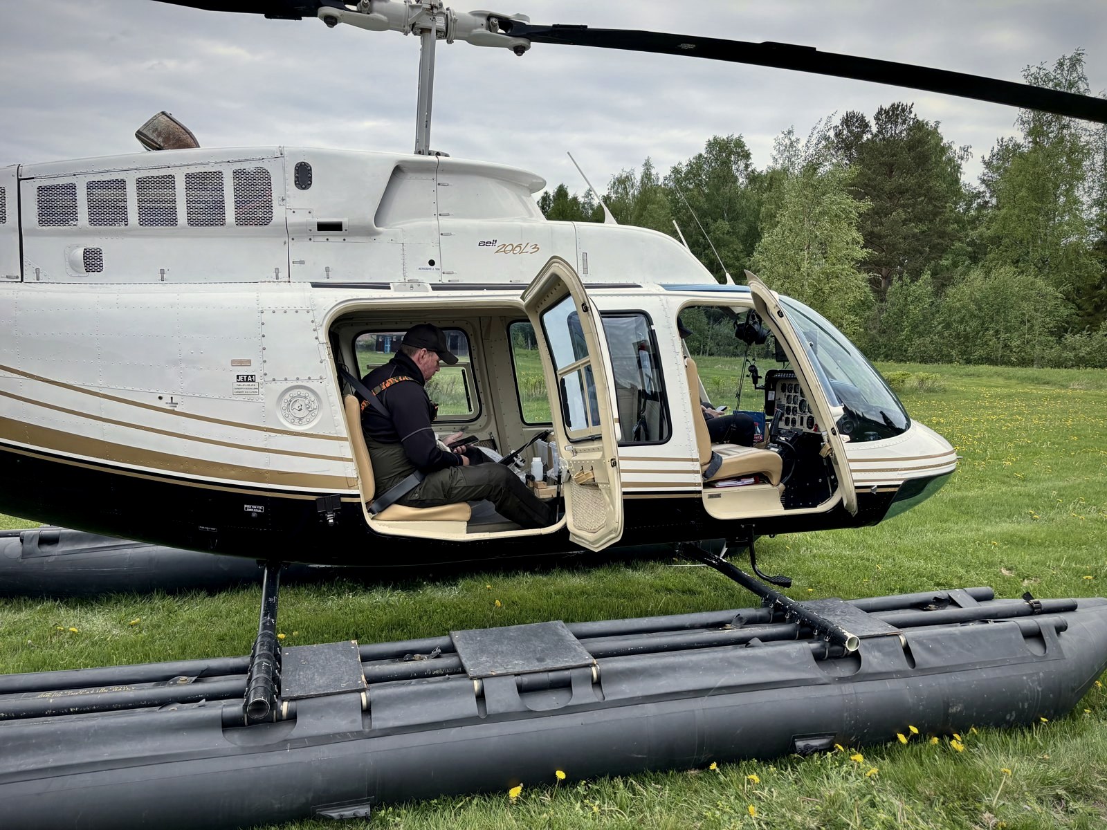 Bell 206L-3 med flottörer på gräsplan