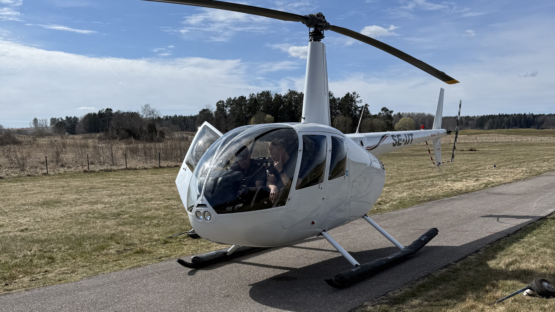 Robinson R44 på Åkersberga flygfält med instruktör och elev